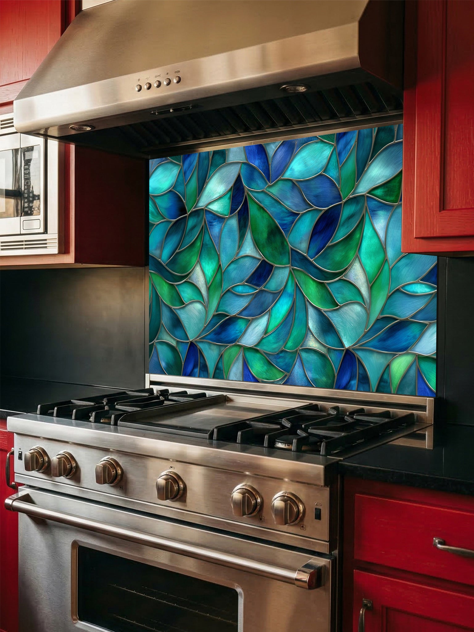 Tempered glass kitchen backsplash featuring a vibrant botanical stained glass effect with overlapping leaves in shades of teal, blue, and emerald green, installed behind a modern stainless steel stove.