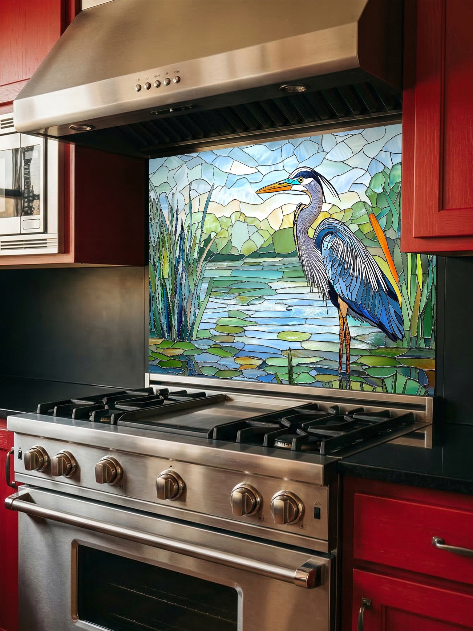 Tempered glass kitchen backsplash featuring a bright faux stained glass design of a majestic blue heron standing among lily pads against a clear blue sky and tranquil wetland, installed behind a modern stainless steel stove.